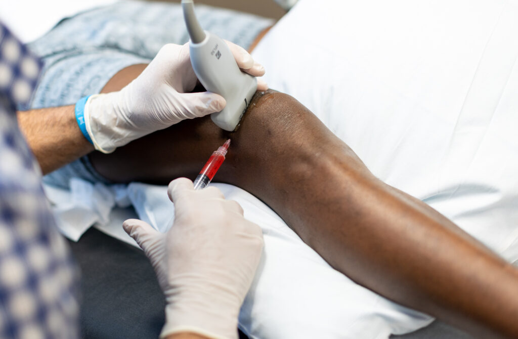 Provider injecting PRP into patient's knee after discussing "what is prp"