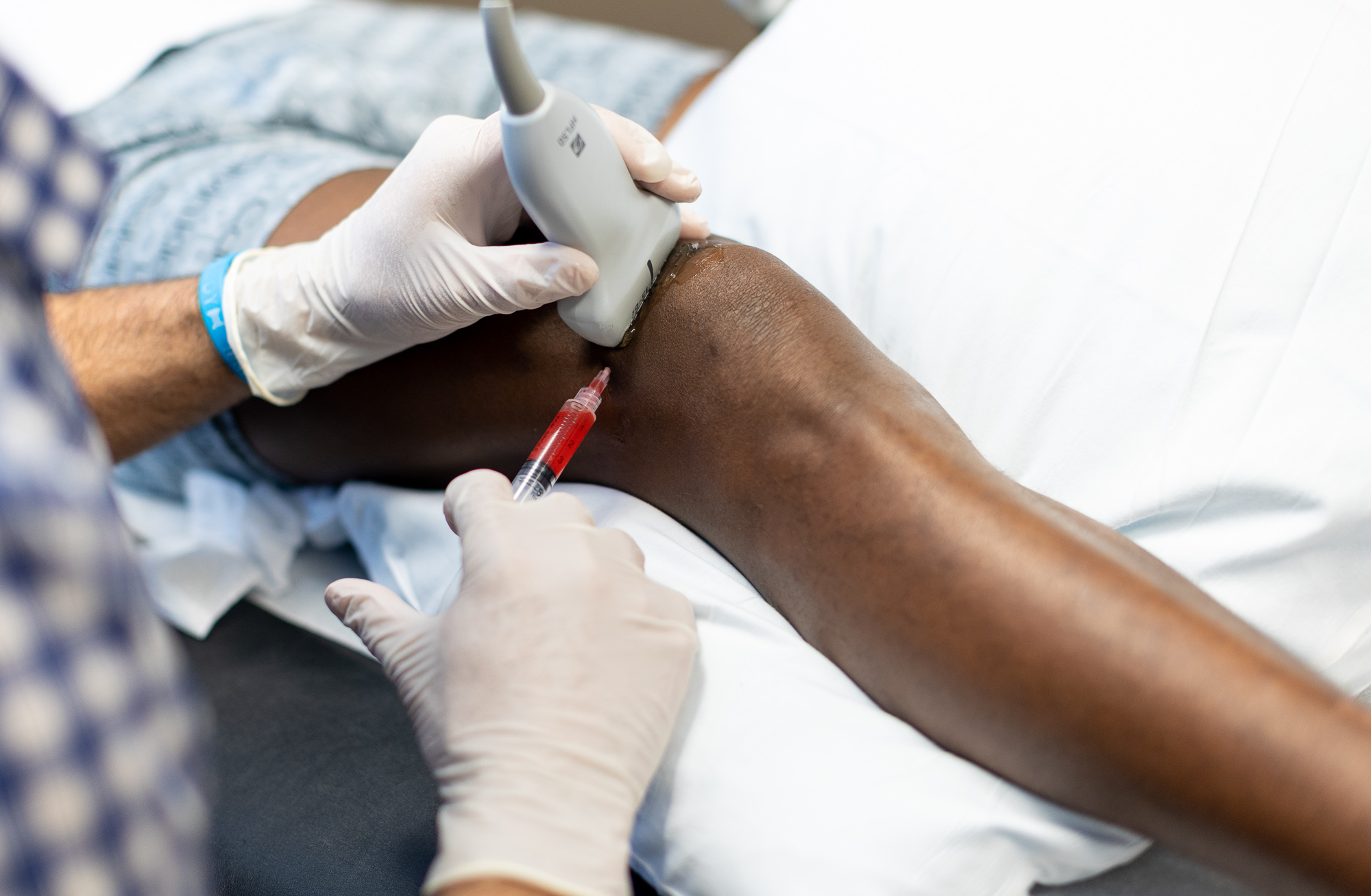 Provider injecting PRP into patient's knee after discussing "what is prp"