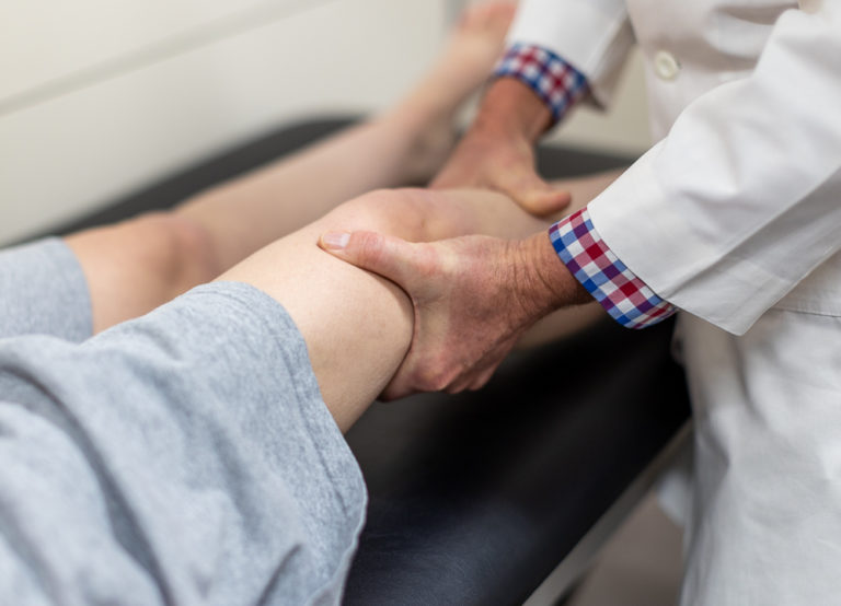 KCOA doctor examining a patient's knee.