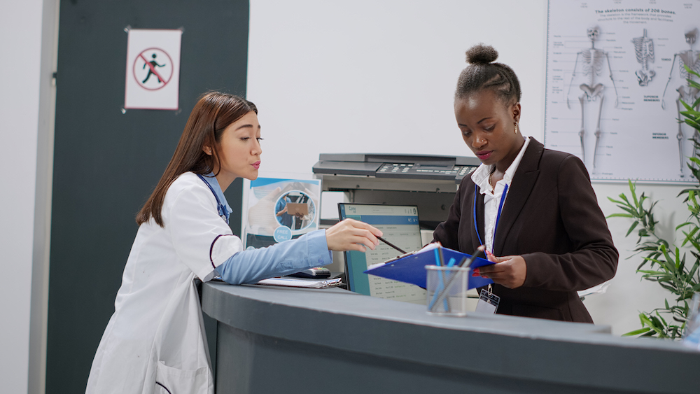 Doctor and receptionist discussing medical reception jobs in Kansas City