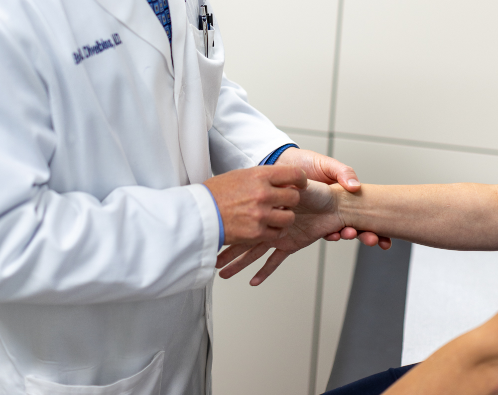 Carpal tunnel surgeon in Kansas City examining patient's wrist
