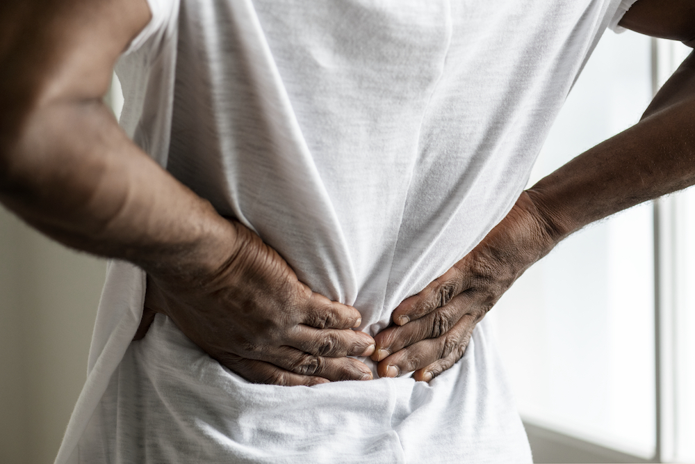 Man holding his back and looking for sciatic nerve pain relief in Kansas City